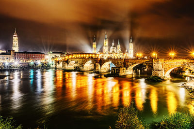 The ebro river at night in zaragoza, spain at the back of the basílica de nuestra señora del pilar