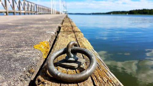 Close-up of metal railing by river