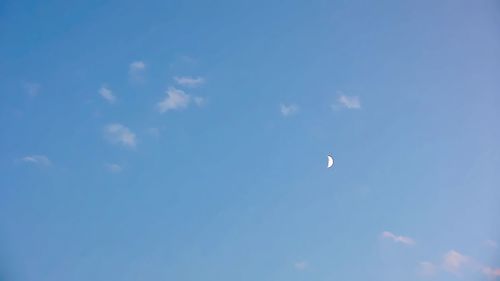 Low angle view of moon in blue sky