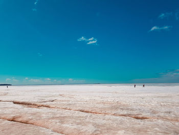 Scenic view of beach against blue sky