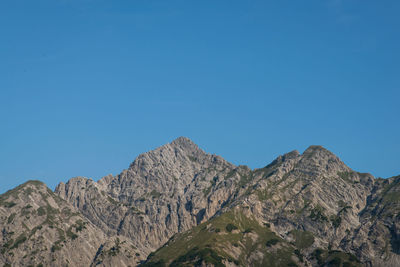 Low angle view of mountain against blue sky