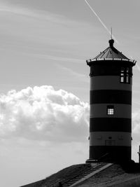 Delightful lighthouse with sunlight through windows against a sky in black and white