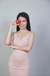 Portrait of a smiling young woman against white background