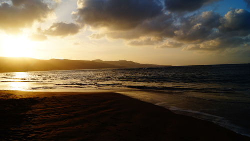 View of calm beach at sunset