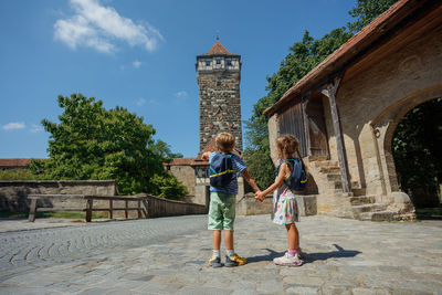 Rear view of woman standing against built structures