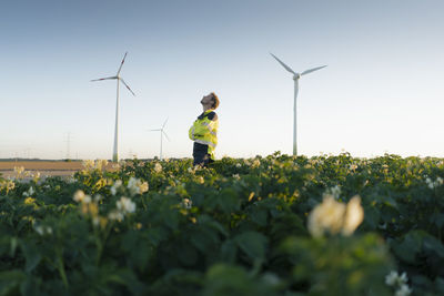 Engineer standing in a field at a wind farm