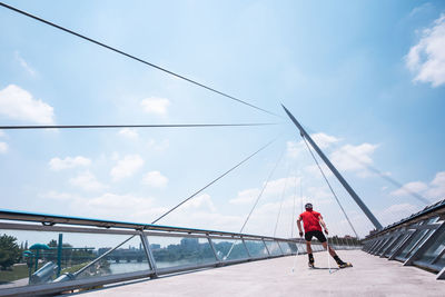 Rear view of athlete ski rolling on bridge