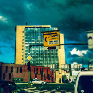 Low angle view of road sign against sky in city