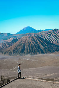 Full length of man on arid landscape against clear sky