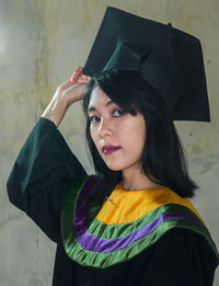 Portrait of beautiful woman standing against wall