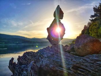 Scenic view of rocks in sea against sky during sunset