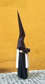 Woman in costume standing by wall