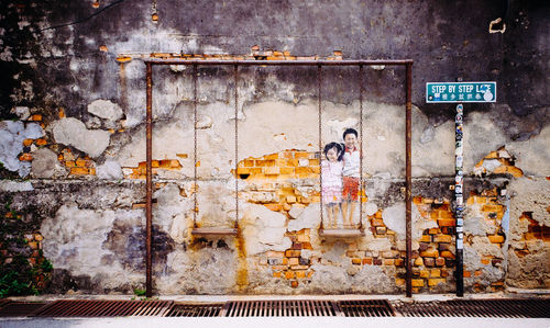 Man standing by graffiti on wall