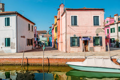 Canal amidst buildings in city against clear sky