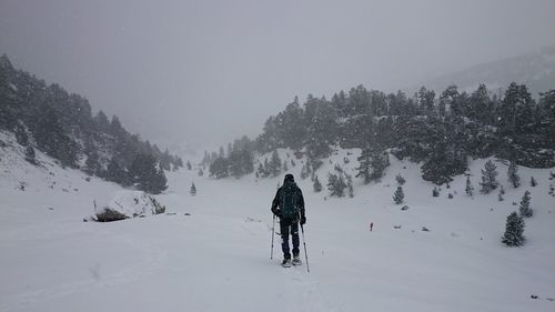 Man on snow covered landscape against sky