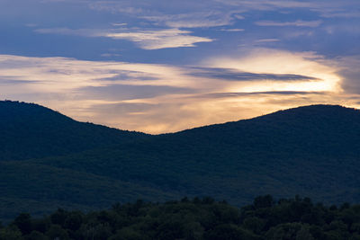 Scenic view of mountains against sky at sunset