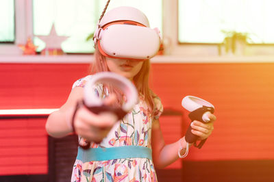 Vr game virtual reality. kid girl gamer playing on futuristic simulation video game in 3d glasses