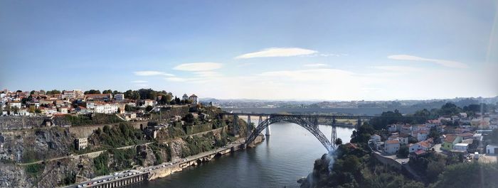 Bridge over river in city against sky