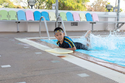Portrait of boy sitting in swimming pool