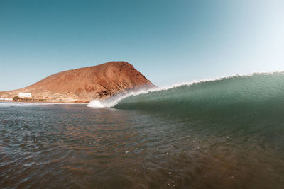 Sea wave against clear blue sky