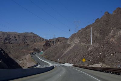 Road by mountain against clear sky