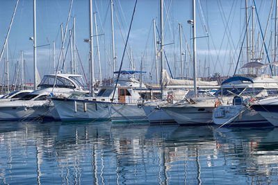 Sailboats moored on sea against sky