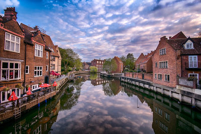 Canal amidst buildings in town against sky