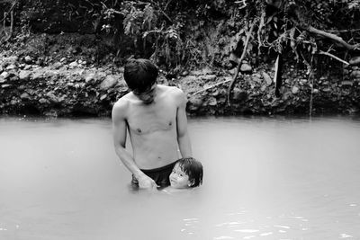 Portrait of girl with father swimming in lake