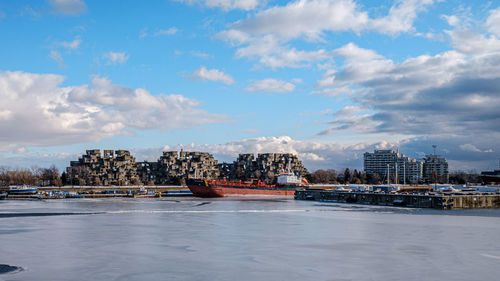 Scenic view of sea by buildings against sky