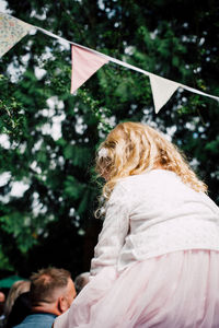 Low angle view of girl against trees