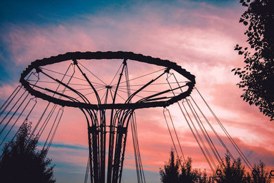 Low angle view of silhouette ferris wheel against sky