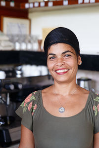 Portrait of smiling woman standing in restaurant