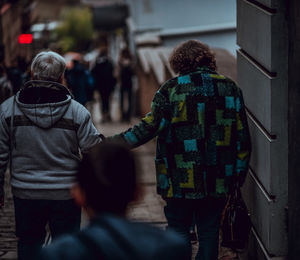 Rear view of couple holding hands while moving down on steps