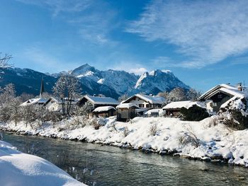 Houses by snowcapped mountains against sky