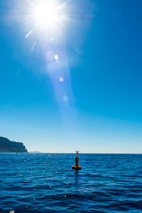 Scenic view of sea against clear blue sky