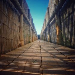 Walkway amidst buildings against sky