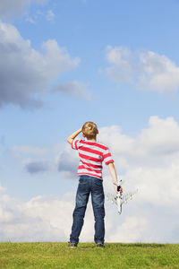 Full length of girl standing on field against sky