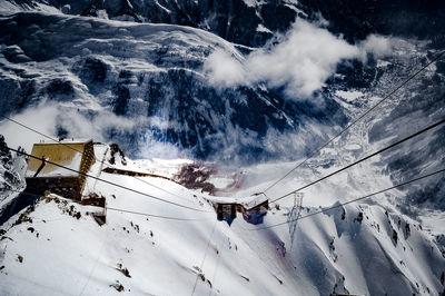 Aerial view of ski lift over snowcapped mountains