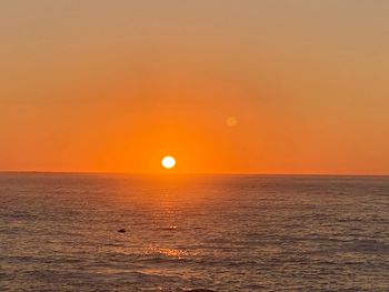 Scenic view of sea against orange sky