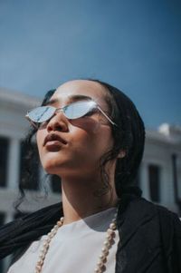 Portrait of woman wearing sunglasses against sky