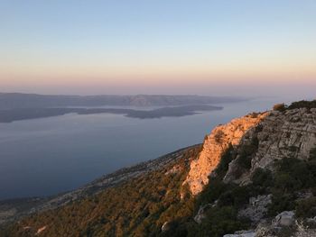 Scenic view of sea and mountains against clear sky