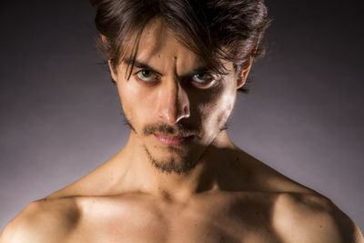 Close-up portrait of young man against gray background