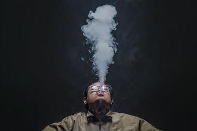 Portrait of man against black background