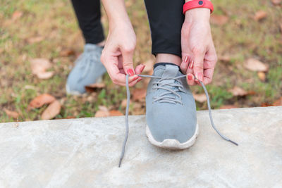 Low section of woman tying shoelace