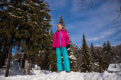 Portrait of child standing on snow covered land