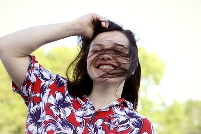 Portrait of smiling woman with arms raised