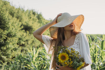 Woman wearing hat against plants