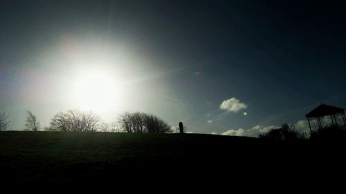 Silhouette trees on landscape against sky