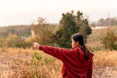 Rear view of woman standing on field