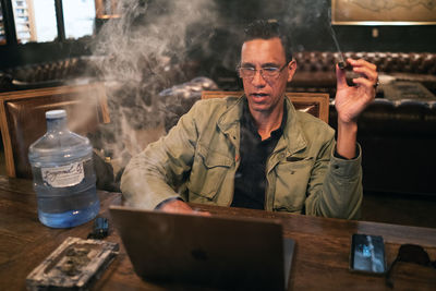 Portrait of man sitting on table